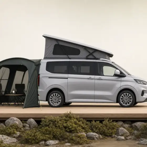 Silbergrauer Ford Nugget mit hinten hohem Aufstelldach und Campingausrüstung im PFAHL 3D-Stil